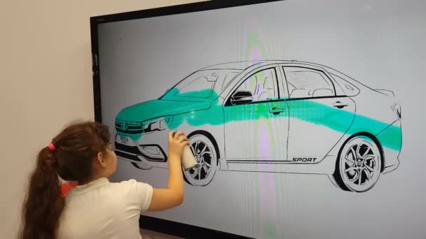 Uma menina pinta um carro em um quadro interativo — Vídeo de Stock