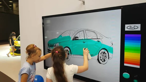 Une fille peint une voiture sur un tableau blanc interactif — Photo