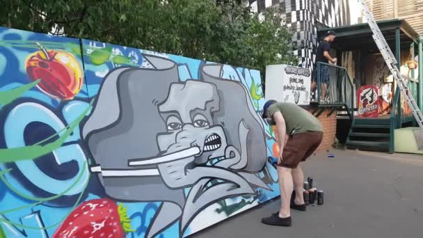 Personer taggning vägg med Graffiti — Stockvideo