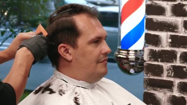 Barbería. Elegante hombre hace un corte de pelo en el barbero . — Vídeos de Stock