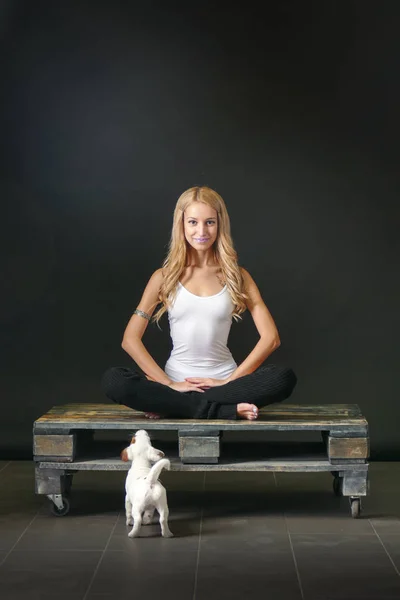 Jovem com filhote de cachorro em pose de ioga — Fotografia de Stock