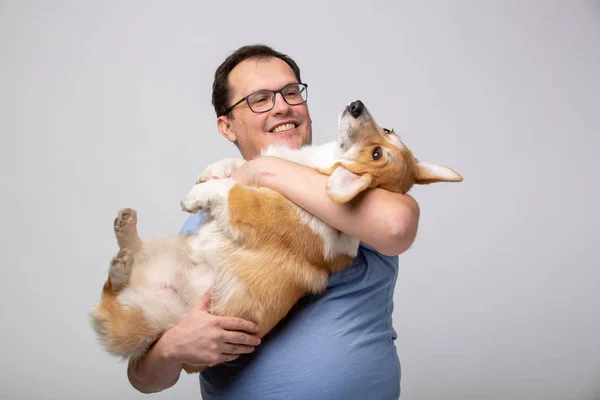 Adulto hombre hold corgi perro — Foto de Stock