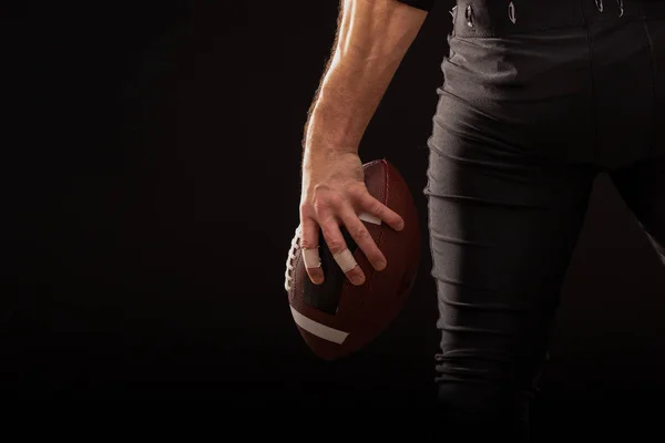 Imagen recortada de Deportista sosteniendo pelota de fútbol americano — Foto de Stock