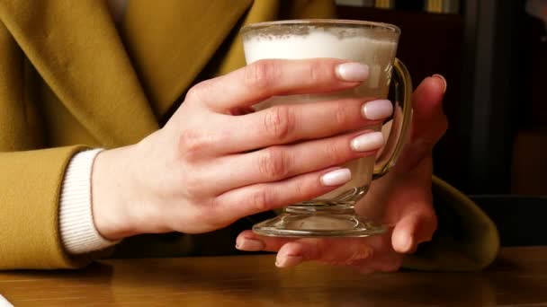 コーヒー ラテからガラス カップ クローズ アップ保持する女性 — ストック動画