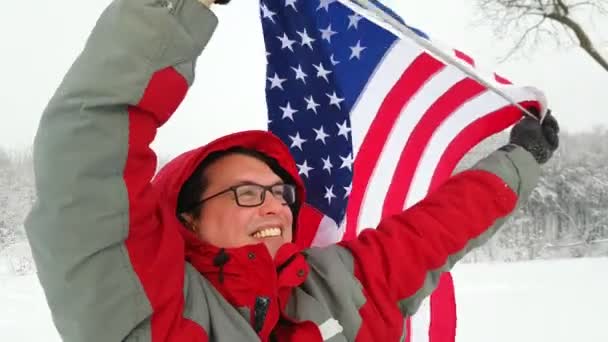 Hombre con bandera estadounidense en una pista de esquí — Vídeos de Stock