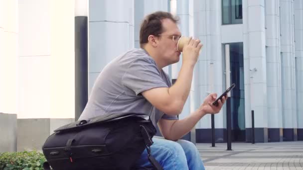 Man met kopje koffie buitenshuis — Stockvideo