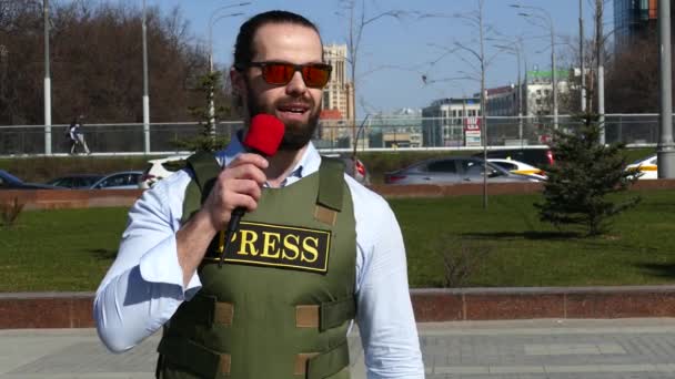 Reporter with a microphone wearing a vest — Stock Video