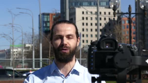 Блогер з містом на фоні крупним планом портрет — стокове відео