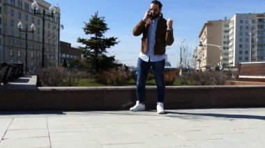 Bir adam uzun süre telefonda konuşuyor ve öfkeyle kırıyor.