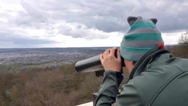 Hombre mirando a través de prismáticos a la ciudad desde el mirador en la montaña — Vídeo de stock