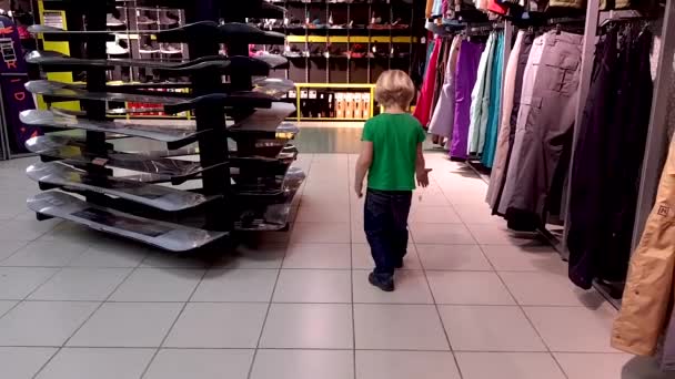 Ребенок собирает потерянные монеты в магазине — стоковое видео