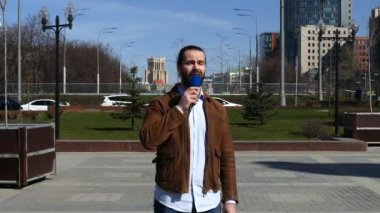 Bir tv muhabiri sokaktan haber veriyor.