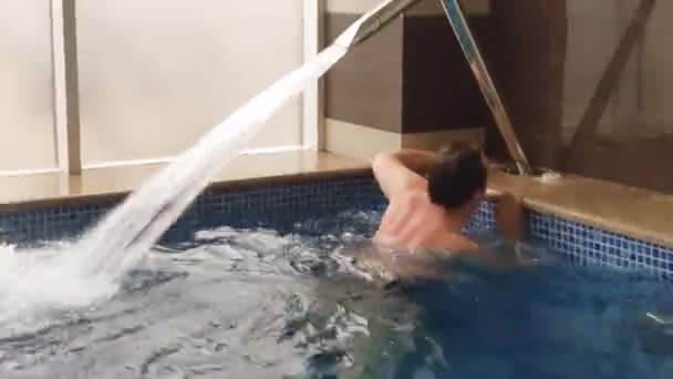 Дорослий чоловік вимкнути басейн водний струмінь масаж — стокове відео
