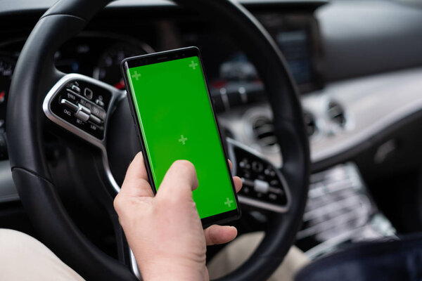 Man hold smartphone in car on dashboard background