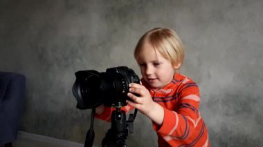 Bir çocuk gerçek bir fotoğraf makinesi ile oynar