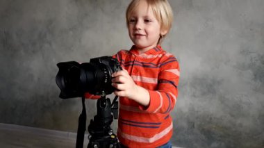 Bir çocuk gerçek bir fotoğraf makinesi ile oynar