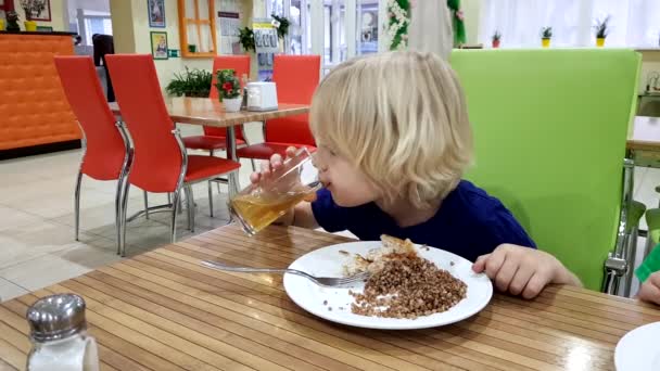 Мальчик в кафе за тарелкой гречневой каши — стоковое видео