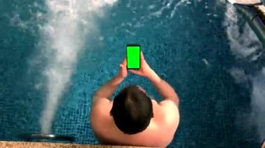 Yetişkin erkekler havuzda dinlenir.