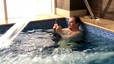 Yetişkin erkekler havuzda dinlenir.