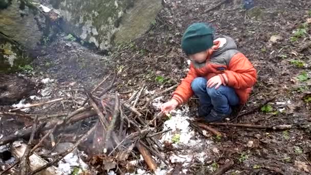 Niño sentado frente al fuego — Vídeos de Stock