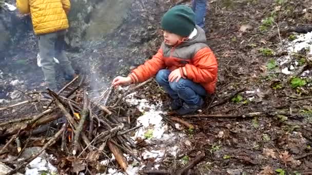 Niño sentado frente al fuego — Vídeos de Stock