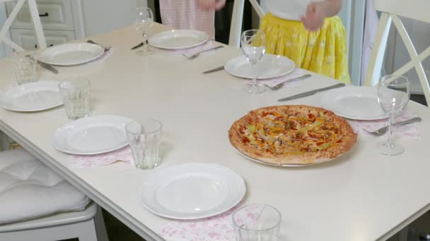 A lány a pizzát intézi az asztalra — Stock videók