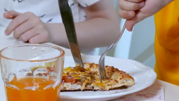 Kid handen knippen een stukje pizza. — Stockvideo