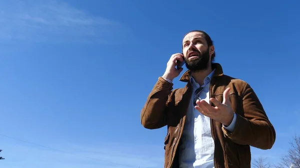 El hombre jura activamente con el interlocutor por teléfono — Foto de Stock
