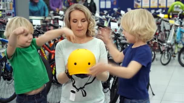 Gemelos pelean en la tienda por el nuevo casco de bicicleta — Vídeo de stock