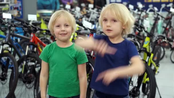 Gemelos están discutiendo la compra de una nueva bicicleta . — Vídeo de stock