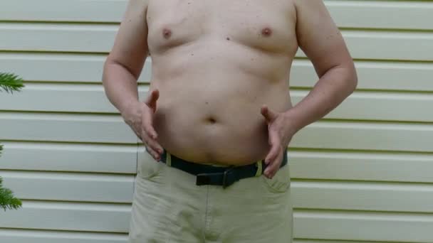 Tłuszcz człowiek puka na jego tłuszcz brzuch — Wideo stockowe