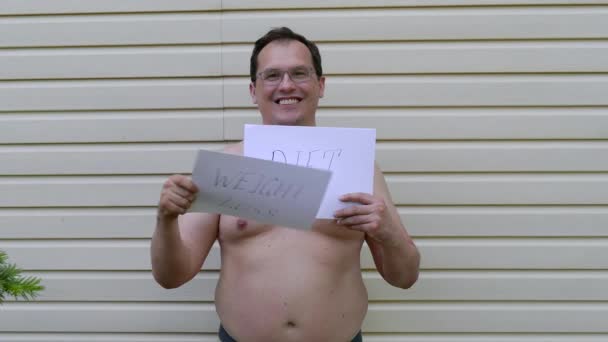 Hombre Gordo hojeando papeles con inscripciones sobre un estilo de vida saludable — Vídeos de Stock