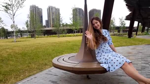 Jolie femme tournant sur le banc dans le parc — Video