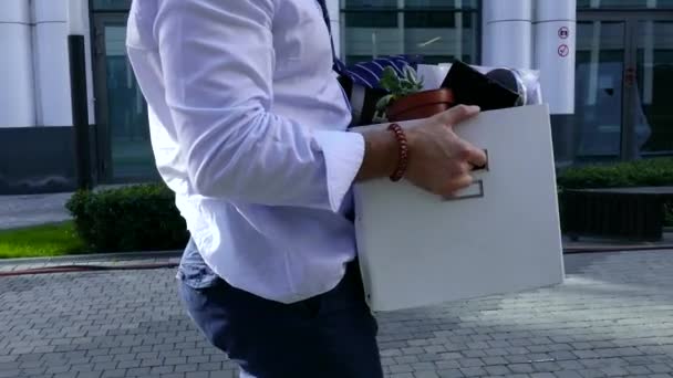 Um homem carrega uma caixa grande com coisas do escritório — Vídeo de Stock