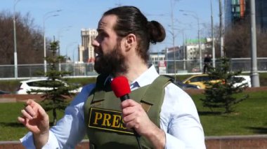 Yelek giyen mikrofonlu muhabir