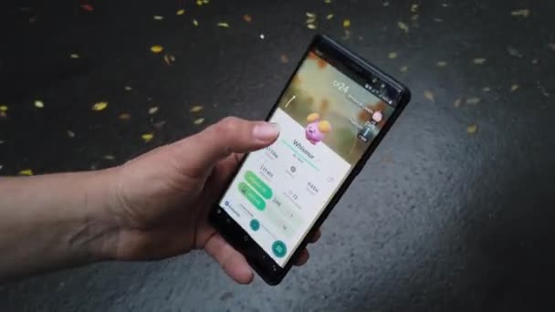 Çalışan bir Pokemon Go uygulaması ile Samsung Galaxy akıllı telefon tutan erkek el — Stok video