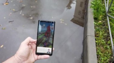 Erkek el çalışan bir Wizard Unite oyun uygulaması ile akıllı telefon tutar