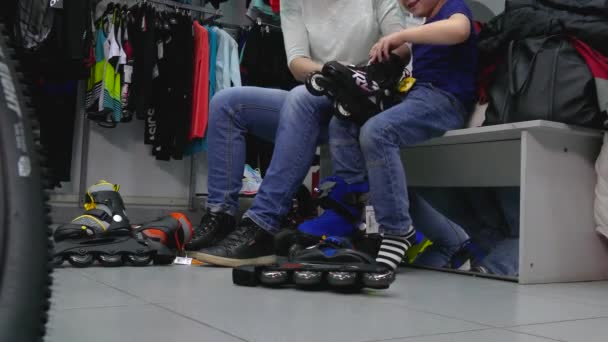 Los compradores miden los patines para un niño In Store . — Vídeos de Stock