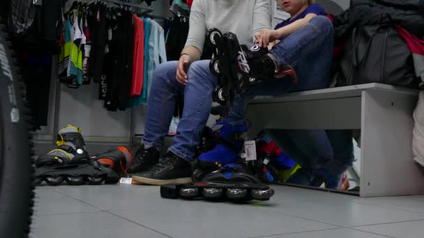 Los compradores miden los patines para un niño In Store . — Vídeos de Stock