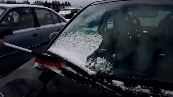 El hombre limpia el coche de la nieve — Vídeos de Stock