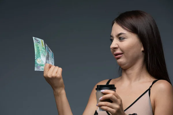 Scioccato ragazza tenere cofe e banconota dinaro kuwaitiano in mano . — Foto Stock