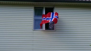 Evdeki pencerede bayrak sallayan gençler