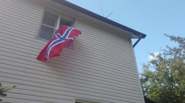 Evdeki pencerede bayrak sallayan gençler