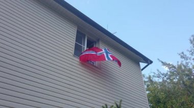 Evdeki pencerede bayrak sallayan gençler