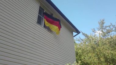 Evdeki pencerede bayrak sallayan gençler