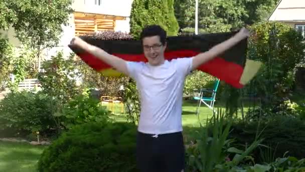 Jóvenes ondeando una bandera al aire libre — Vídeos de Stock