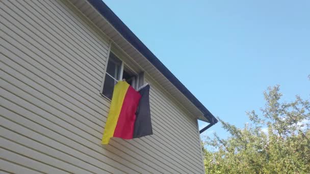 Jovens acenando uma bandeira em uma janela em casa — Vídeo de Stock