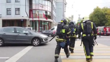 Bir grup itfaiyeci üniformayla sokakta yürüyor