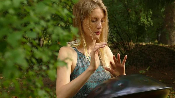 Playing The Instrument Hung. Woman Hands Playing The Hang outdoors.