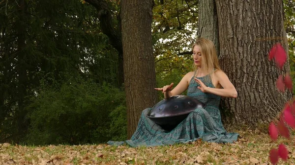 Szép fiatal nő játszik a felfüggeszt az őszi parkban — Stock Fotó